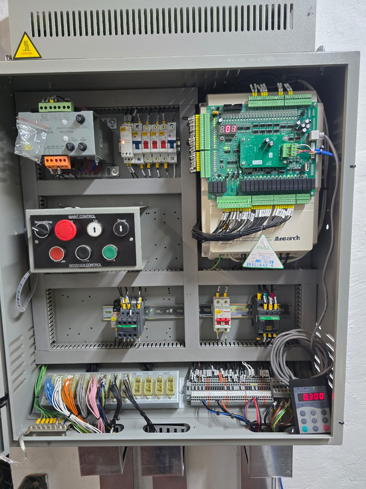 Modern lift control cabinet with a variable frequency drive, controller board, maintenance control panel, breakers and neatly loomed, labelled wiring.