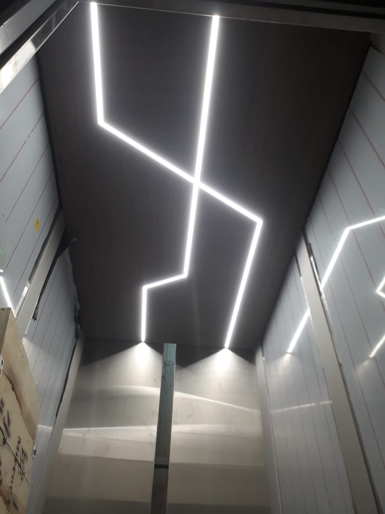 Lift ceiling with an angular geometric LED light-line design, fitted during the cab build.